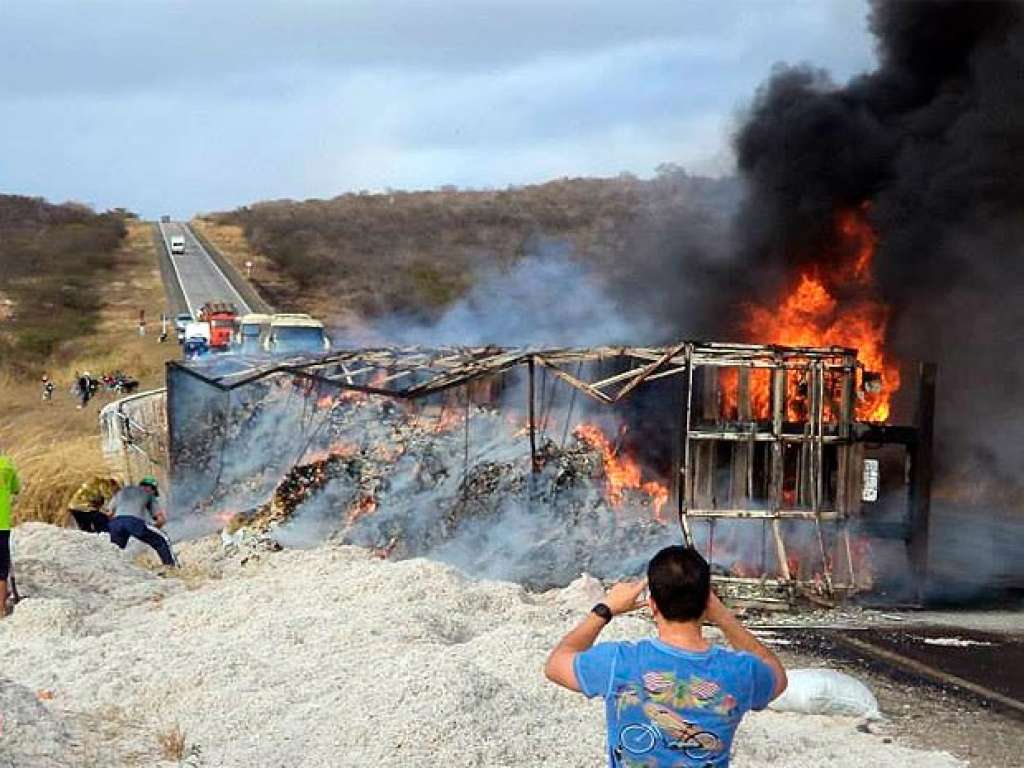 Caminhão carregado de caroço de algodão tomba e veículo pega fogo