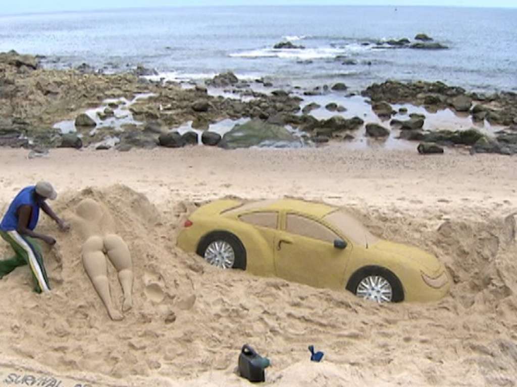 Artista constrói carro de areia na praia do Porto da Barra