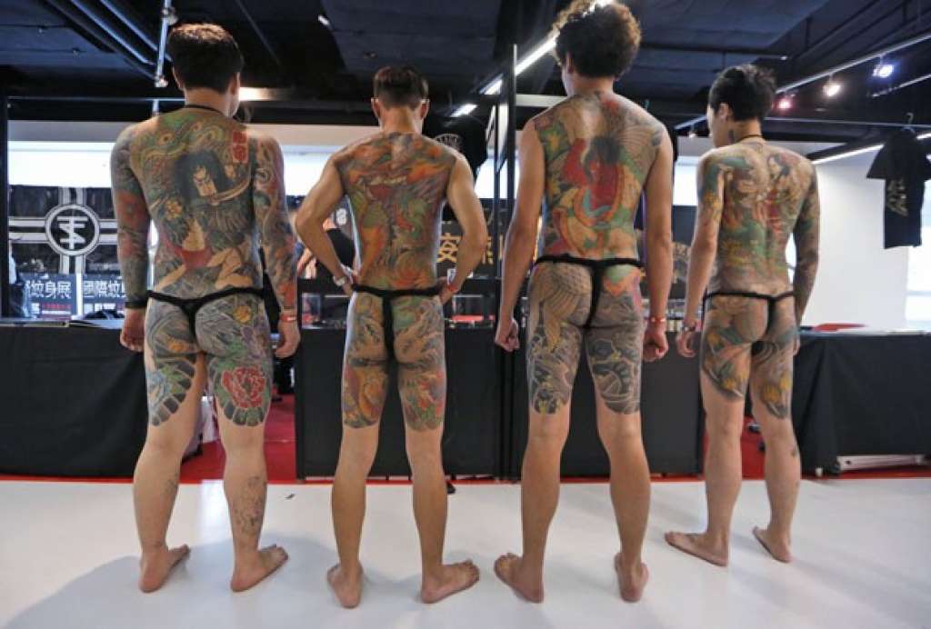 De tanga fio-dental, participantes exibem corpos tatuados na China
