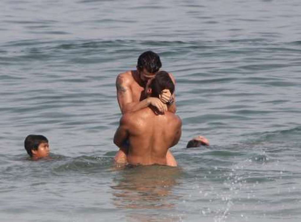 Modelo e ator são flagrados aos beijos em praia