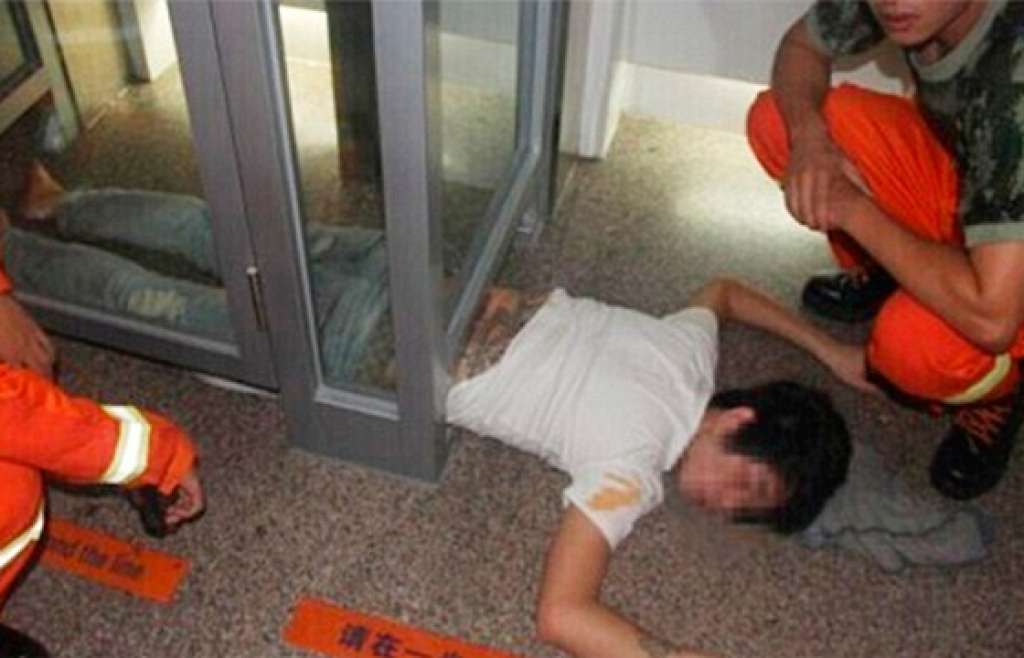 Bêbado fica preso ao tentar passar por baixo de porta