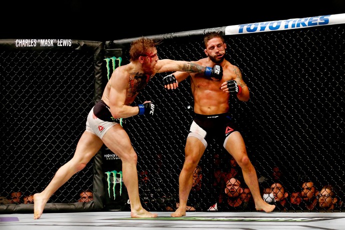 Conor McGregor acerta um direto de esquerda no rosto de Chad Mendes (Foto: Getty Images)