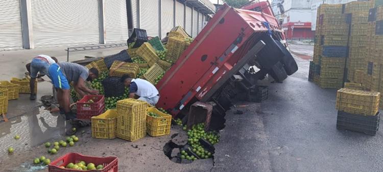 Feira de Santana: Caminhão de frutas tomba após ficar preso em Cratera