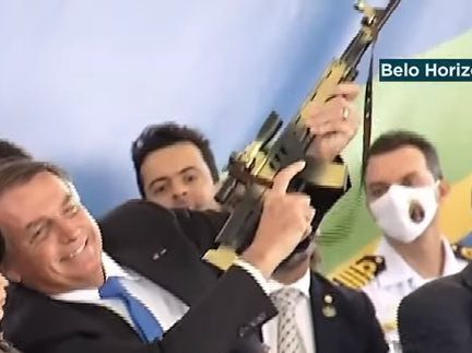 Bolsonaro levanta metralhadora de brinquedo e diz que criança que segurava a arma de plástico é “exemplo de civilidade”