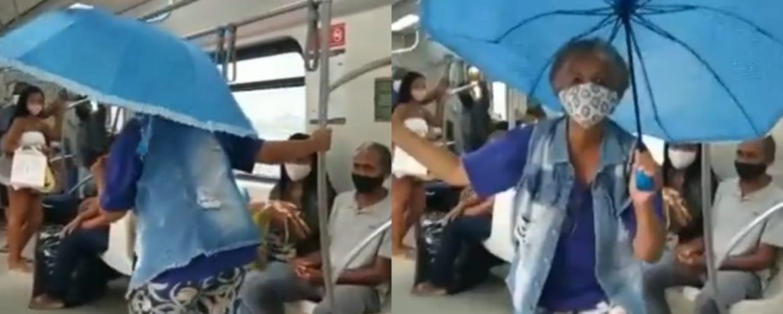 Mulher abre guarda-chuva para se protege de goteiras dentro do metrô