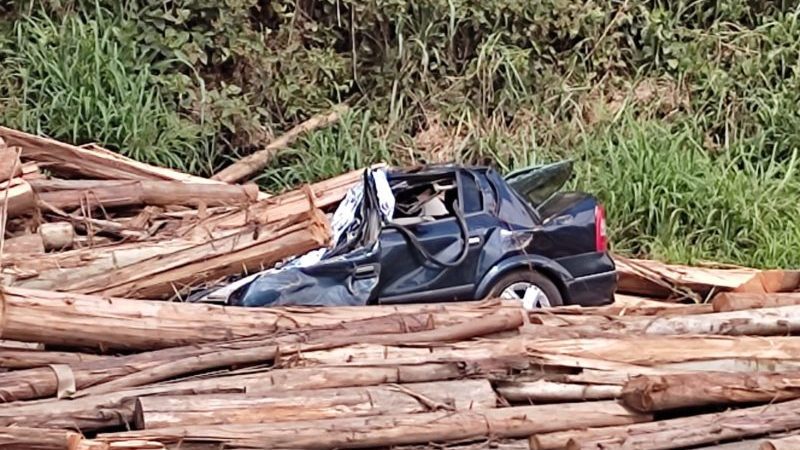 Homem morre após ter carro atingido por carga de madeira que caiu de caminhão